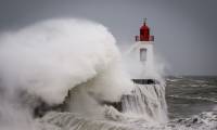 Des vagues s'écrasent contre le phare à l'entrée du port des Sables-d'Olonne, pendant la tempête Nelson, le 28 mars 2024 en Vendée ( AFP / LOIC VENANCE )
