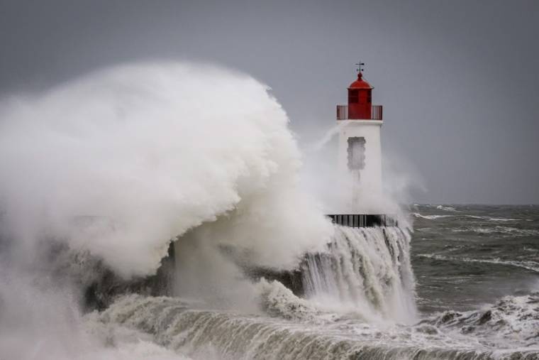 Des vagues s'écrasent contre le phare à l'entrée du port des Sables-d'Olonne, pendant la tempête Nelson, le 28 mars 2024 en Vendée ( AFP / LOIC VENANCE )