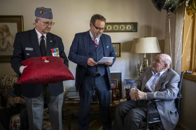 Le consul général de France Damien Laban (c) remet la Légion d'honneur à Jack Hausman (d), vétéran de la Seconde Guerre mondiale, lors d'une cérémonie, le 26 avril 2024 à New York ( AFP / ANGELA WEISS )