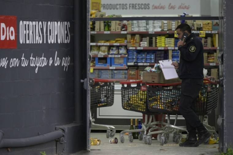 Un policier dans un supermarché pillé, le 22 août 2023 à José C. Paz, faubourg populaire près de Buenos Aires, en Argentine ( AFP / Juan MABROMATA )