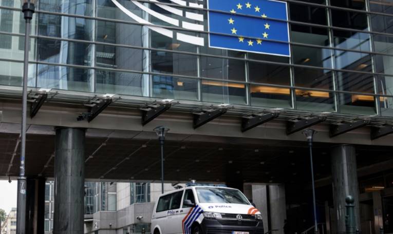 Un véhicule de la police belge devant le Parlement européen où des perquisitions sont menées, le 29 mai 2024 à Bruxelles ( AFP / Kenzo TRIBOUILLARD )