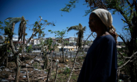 Une femme parmi les maisons détruites d'un bidonville endommagé par le cyclone Chido à Mamoudzou, sur le territoire de Mayotte, le 31 décembre 2024 ( AFP / JULIEN DE ROSA )