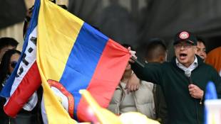 Le président colombien Gustavo Petro agite le drapeau national à l'occasion de son discours, le 1er mai à Bogota ( AFP / Raul ARBOLEDA )