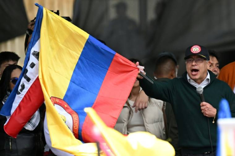 Le président colombien Gustavo Petro brandit le drapeau national lors d'un  discours à Bogota, le 1er mai 2024 ( AFP / Raul ARBOLEDA )