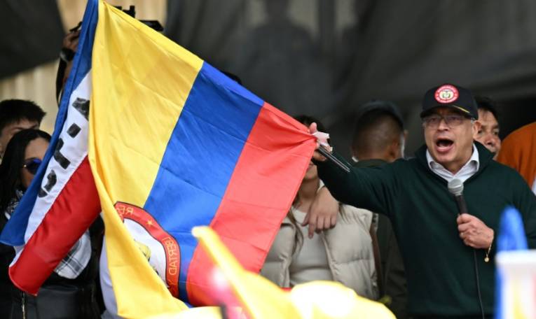 Le président colombien Gustavo Petro agite le drapeau national à l'occasion de son discours, le 1er mai à Bogota ( AFP / Raul ARBOLEDA )