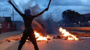 Un manifestant à Maputo le 23 décembre 2024 en début de soirée ( AFP / Amilton Neves )