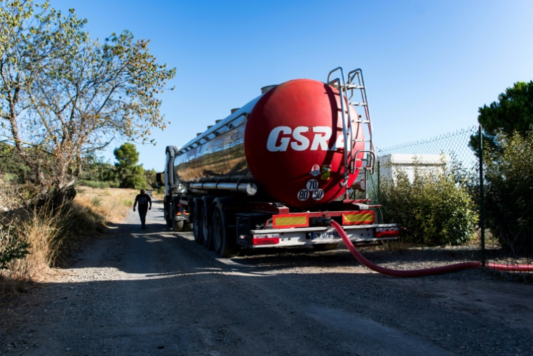 Un camion-citerne remplit un réservoir d'eau du village de Durban-Corbières privé d'eau courante plusieurs heures par jour en raison de la sécheresse, le 22 août 2024 dans l'Aude ( AFP / Matthieu RONDEL )