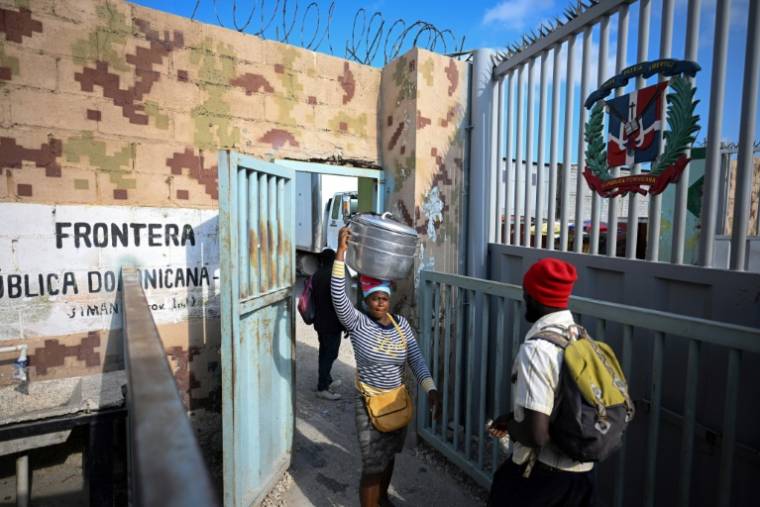 Des Haïtiens traversent la frontière entre Malpasse en Haïti et Jimani en République dominicaine pour travailler au marché binational de Jimani, le 15 mai 2024 ( AFP / Federico Parra )