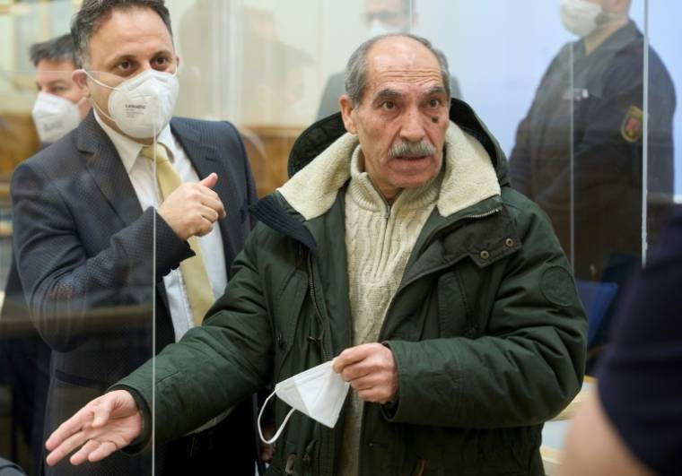 L'ancien colonel syrien Anwar Raslan (d), fait un geste à côté de l'un de ses avocats dans la salle d'audience du tribunal de Coblence, dans l'ouest de l'Allemagne, le 13 janvier 2022 ( POOL / Thomas Frey )