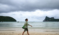 Elisabeth Zana, fondatrice de l'association NAT, qui a perdu sa fille Natacha dans le tsunami de 2004, marche sur une plage en direction du parc commémoratif du tsunami à Koh Phi Phi, le 21 novembre 2024 en Thaïlande ( AFP / Manan VATSYAYANA )