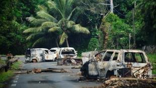 Des véhicules calcinés sur une route traversant la commune de Mont-Dore, en Nouvelle-Calédonie, le 10 juin 2024  ( AFP / Theo Rouby )