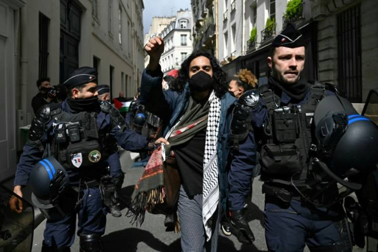 Un manifestant est escorté par des gendarmes français lors de l'évacuation de manifestants qui avaient organisé un sit-in contre l'offensive israélienne à Gaza, dans le hall de l'école Sciences Po à Paris, le 3 mai 2024 ( AFP / Miguel MEDINA )