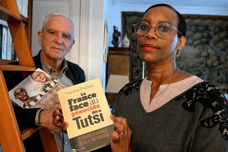 Alain Gauthier et son épouse Dafroza Mukarumongi-Gauthier, cofondateurs du Collectif des parties civiles pour le Rwanda, montrent des livres sur le génocide rwandais, chez eux, le 26 mars 2024 à Reims ( AFP / FRANCOIS NASCIMBENI )