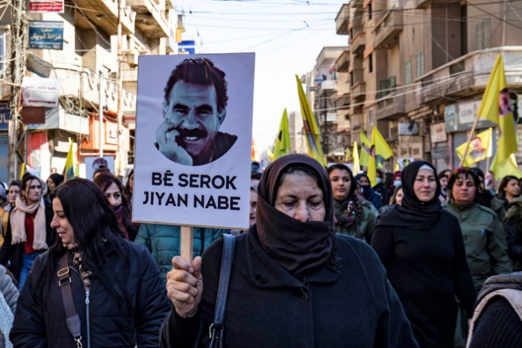 Des manifestants brandissent des drapeaux jaunes et un portrait représentant le visage d'Abdullah Öcalan, le chef du Parti des travailleurs du Kurdistan (PKK), actuellement emprisonné en Turquie, lors d'une manifestation à Qamishli, dans le nord-est de la Syrie, le 15 février 2023 ( AFP / Delil SOULEIMAN )