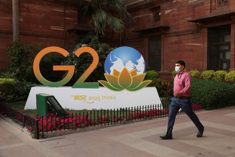 Un homme passe devant une maquette du logo du G20 devant le ministère des finances à New Delhi