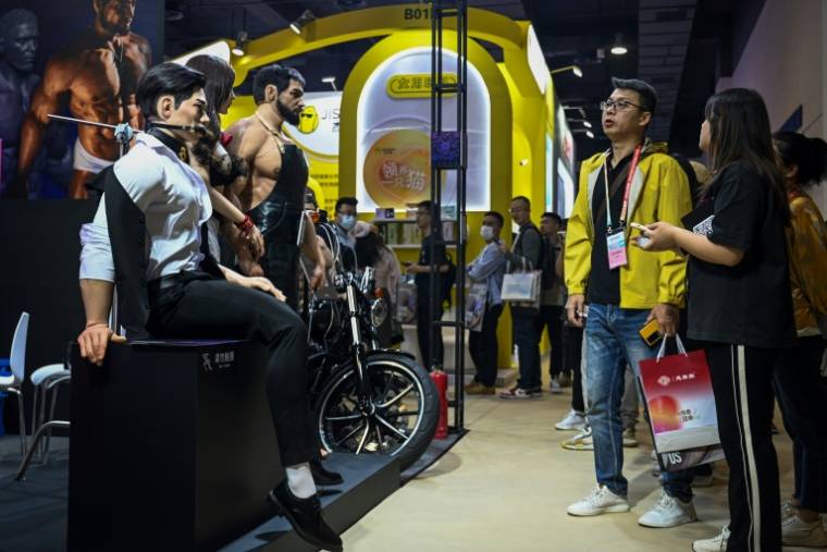 Des visiteurs regardent des poupées sexuelles exposées au salon international des produits pour adultes à Shanghai, le 19 avril 2024 en Chine ( AFP / STR )