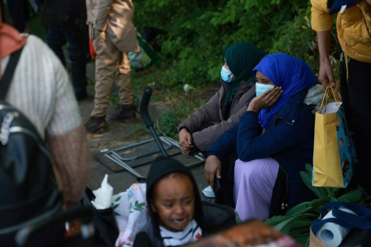 Des familles évacuées du plus grand squat de France attendent de savoir où aller, à Vitry-sur-Seine, le 17 avril 2024 ( AFP / Emmanuel Dunand )