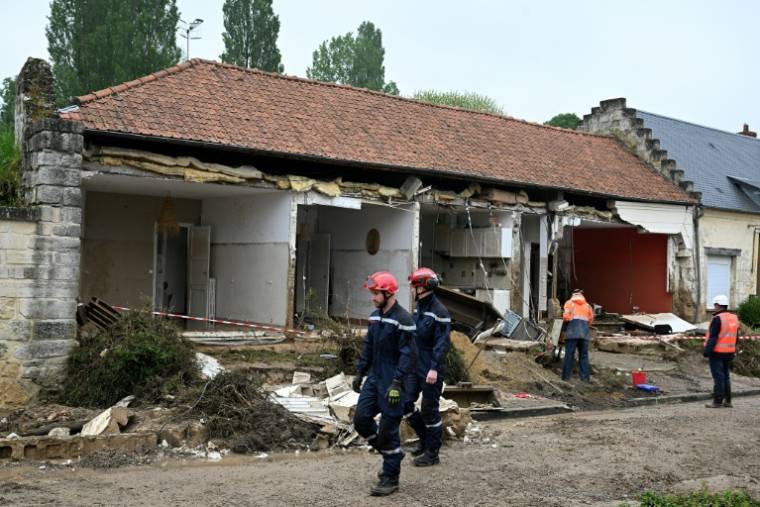 Des pompiers devant une maison éventrée par une coulée de boue pendant des orages, provoquant le décès d'une femme, le 2 mai 2024 à Courmelles, dans l'Aisne ( AFP / FRANCOIS NASCIMBENI )