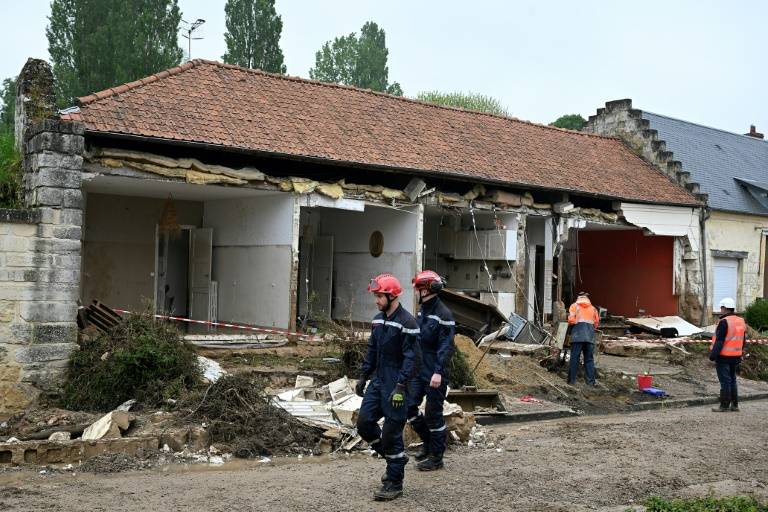 Des pompiers devant une maison éventrée par une coulée de boue pendant des orages, provoquant le décès d'une femme, le 2 mai 2024 à Courmelles, dans l'Aisne ( AFP / FRANCOIS NASCIMBENI )