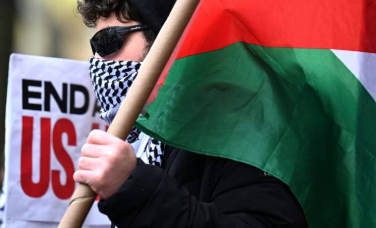 Un manifestant pro-palestinien porte le drapeau palestinien devant le campus de l'université Columbia à New York, aux Etats-Unis, le 24 avril 2024 ( AFP / TIMOTHY A. CLARY )