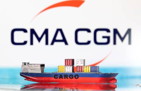 Un modèle de navire cargo représenté devant le logo de CMA CGM