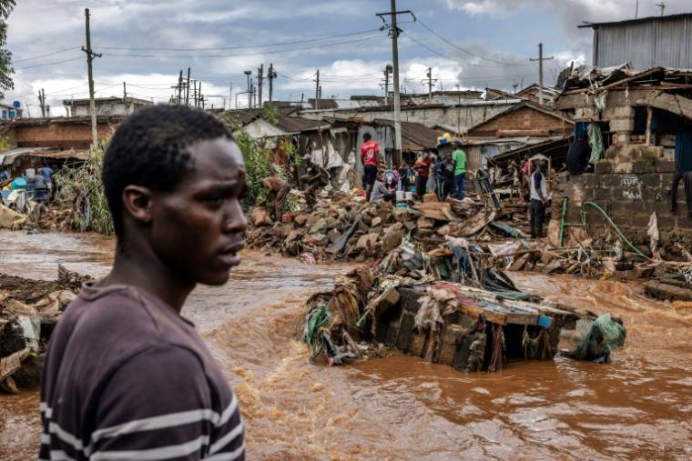 Les habitants du bidonville de Mathare traversent le quartier inondé à la suite de fortes pluies sur Nairobi, le 25 avril 2024 ( AFP / LUIS TATO )