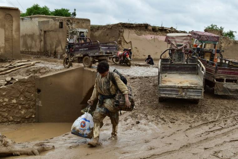 Un homme transporte ses affaires le 11 mai 2024 à Laqiha, un village du nord-est de l'Afghanistan dévasté par des crues subites ( AFP / - )