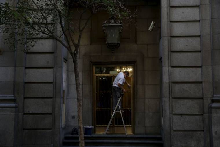 Un homme travaille en nettoyant la porte d'entrée d'un bâtiment