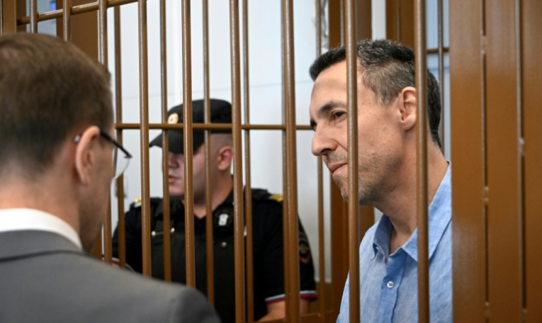 Le Français Laurent Vinatier, accusé de ne pas s'être enregistré en tant qu'"agent de l'étranger", écoute son avocat depuis la cage des accusés lors d'une audience au tribunal du district de Zamoskvoretsky à Moscou, le 3 septembre 2024 ( AFP / Alexander NEMENOV )