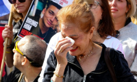 Une femme réagit alors que les gens regardent sur un écran à la place des otages à Tel-Aviv la libération des otages israéliens dans la bande de Gaza, le 1er février 2025 ( AFP / Jack GUEZ )