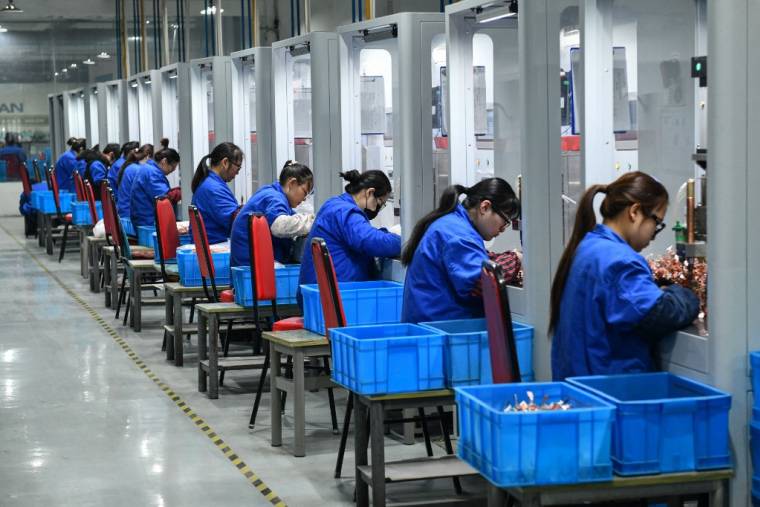 Des employés d'une usine de produits électroniques à Fuyang, en Chine ( AFP / STR )