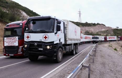 Des camions de la Croix-Rouge dépassent un convoi humanitaire pour le Nagorny Karabakh à l'arrêt, le 23 septembre 2023 près de Kornidzor  ( AFP / ALAIN JOCARD )