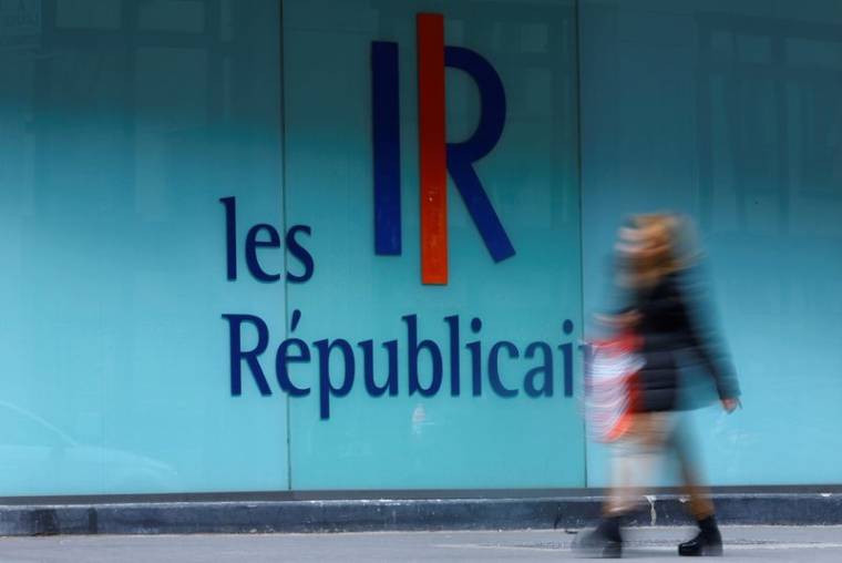 Une femme passe devant un logo du Parti français Les Républicains (LR) à Paris, France