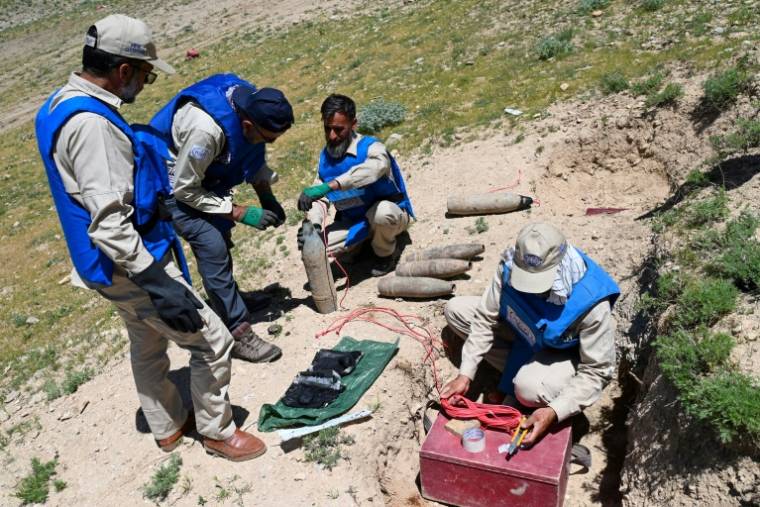 Des démineurs du Halo Trust se préparent à faire exploser des munitions sur une colline dans le district de Deh Sabz, à Kaboul, le 21 mai 2024 en Afghanistan ( AFP / Wakil KOHSAR )