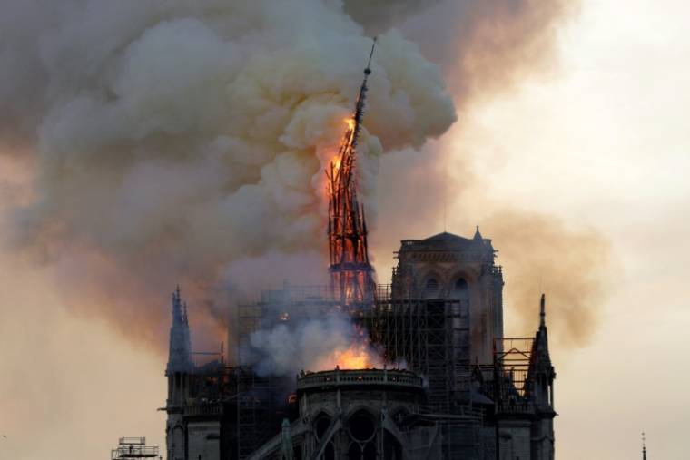 Le clocher et la flèche de la cathédrale Notre-Dame s'effondrent alors que l'édifice est en proie aux flammes dans le centre de Paris, le 15 avril 2019 ( AFP / Geoffroy VAN DER HASSELT )