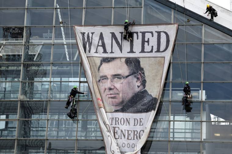Des militants de Greenpeace déploient un portrait géant de Patrick Pouyanne, directeur général de TotalEnergies, lors d'une manifestation avant l'assemblée générale du groupe, à La Défense, près de Paris, le 24 mai 2024 ( AFP / STEPHANE DE SAKUTIN )