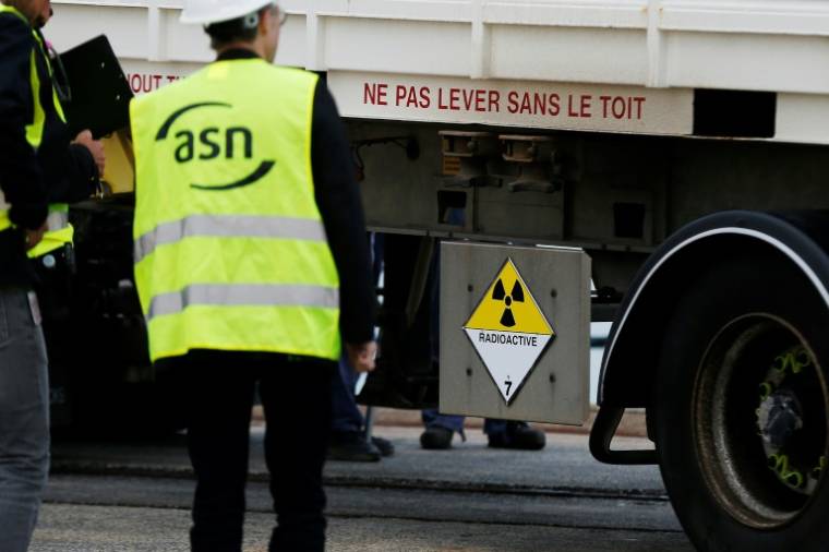 Des membres de l'Autorité de sûreté du nucléaire (ASN) contrôlent un conteneur transportant du combustible nucléaire irradié, le 14 septembre 2018 à Cherbourg dans la Manche ( AFP / CHARLY TRIBALLEAU )