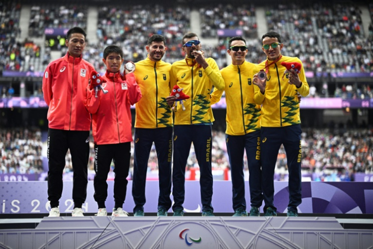 Les médailles du 5000 m T11 des Jeux paralympiques (de gauche à droite): le Japonais Kenya Karasawa (argent, 2e à gauche), et les Brésiliens Julio Cesar Agripino dos Santos (or, 4e à gauche) et Yeltsin Jacques (D), le 30 août 2024 au Stade de France ( AFP / JULIEN DE ROSA )