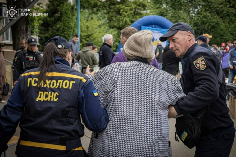 Photo diffusée par les services d'urgence ukrainiens, le 17 mai 2024, montrant des sauveteurs évacuant des civils victimes de bombardements russes dans la région de Kharkiv ( Services d'urgence ukrainiens / - )