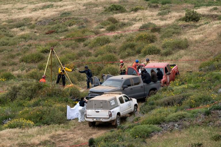 Des secouristes, des médecins légistes et des procureurs travaillent autour d'un trou d'eau où des restes humains ont été trouvés près de la plage de La Bocana, à Ensenada, dans l'État de Basse-Californie, au Mexique, le 3 mai 2024 ( AFP / Guillermo Arias )