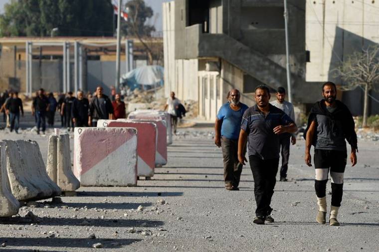 Des ouvriers palestiniens, qui se trouvaient en Israël lors de l'attaque du Hamas du 7 octobre, arrivent à la frontière de Rafah après avoir été renvoyés par Israël dans la bande de Gaza