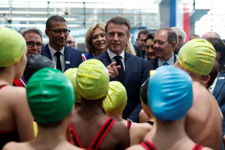 Le président Emmanuel Macron parle avec des enfants lors de l'inauguration du centre aquatique de Saint-Denis, le 4 avril 2024 en Seine-Saint-Denis ( POOL / Gonzalo Fuentes )