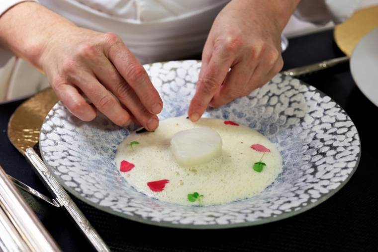 La cheffe Virginie Basselot prépare un "cabillaud nacré" dans les cuisines du restaurant gastronomique "Chanteclerc" de l'Hôtel "Le Negresco", le 12 mars 2024 à Nice ( AFP / Valery HACHE )