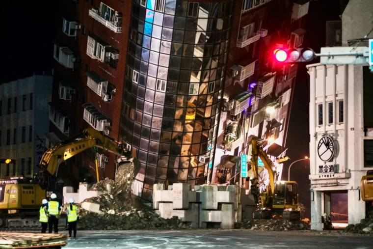 Des équipes de secours devant un immeuble penché et partiellement effondré à Hualien, le 3 avril 2024 après un puissant séisme à Taïwan ( AFP / Sam Yeh )