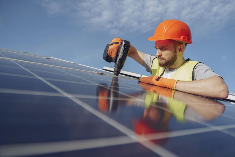 un homme installe un panneau solaire (Crédits: Pexels - Gustavo Fring)