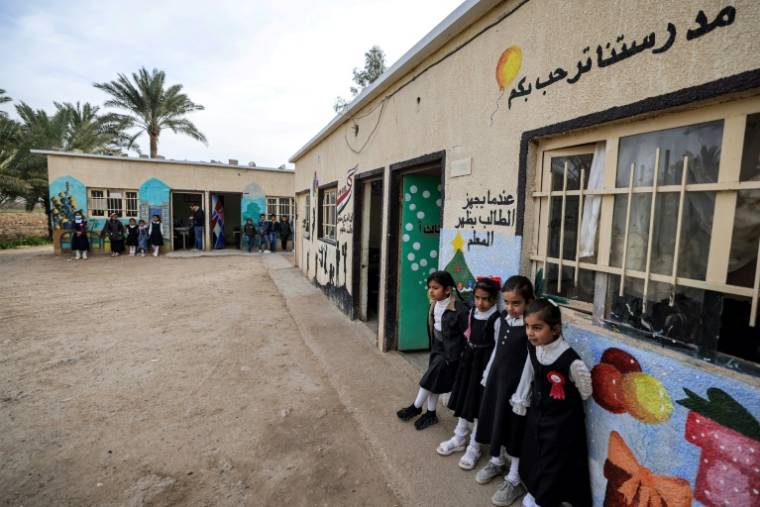 Des élèves se tiennent devant les salles de classe d'une école située dans le centre de l'Irak, le 10 mars 2024 ( AFP / AHMAD AL-RUBAYE )