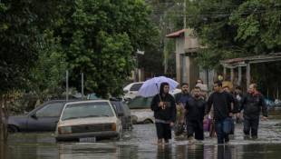 Des habitants se déplacent dans une rue inondée de la ville de Canoas, dans le sud du Brésil, le 13 mai 2024 ( AFP / NELSON ALMEIDA )