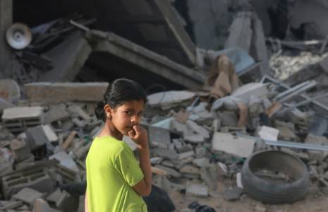Une jeune fille se trouve le 25 avril 2024 devant des gravats d'un bâtiment détruit par un bombardement israélien à Rafah, dans le sud de la bande de Gaza, où Israël combat le mouvement islamiste palestinien Hamas ( AFP / MOHAMMED ABED )