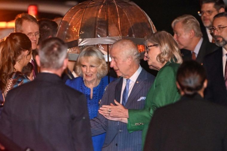 Le roi Charles III (au centre à droite) et la reine Camilla (au centre à gauche) sont accueillis à leur arrivée à l'aéroport international de Sydney vendredi 18 octobre 2024 ( AFP / Saeed KHAN )