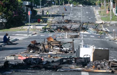 Une rue bloquée par des objets incendiés et des débris, dans le quartier Magenta à Nouméa en Nouvelle-Calédonie, le 18 mai 2024 ( AFP / Delphine Mayeur )